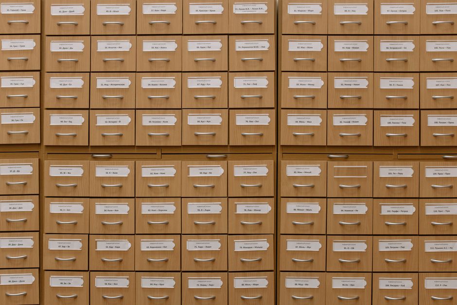 A wall of small wooden card-catalogue drawers with typed labels